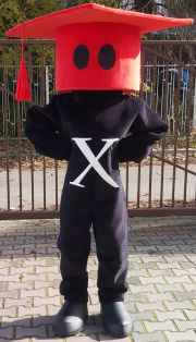 Chłopiec w czarnym kostiumie z czerwonym biretem